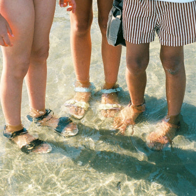 Kinderen die waterproof sandalen van LMDI dragen in de zee